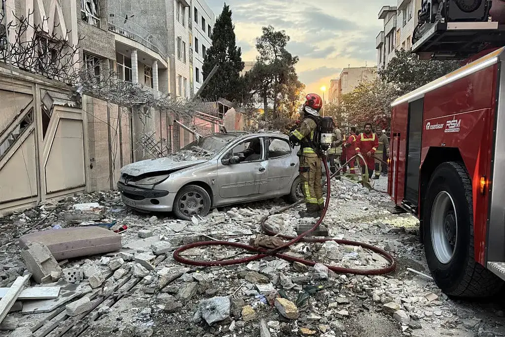 Los equipos de primera respuesta se reúnen frente a un edificio alcanzado por un ataque israelí en Teherán el 13 de junio de 2025. (Meghdad Madad/AFP a través de Getty Images)
