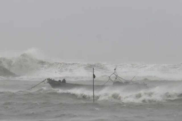 Un barco pesquero atraca para refugiarse en las aguas cercanas a una plaza costera en la ciudad de Yinggehai, condado autónomo de la etnia li de Ledong, provincia de Hainan, sur de China, el 13 de junio de 2025. EFE/EPA/XINHUA/Yang Guanyu