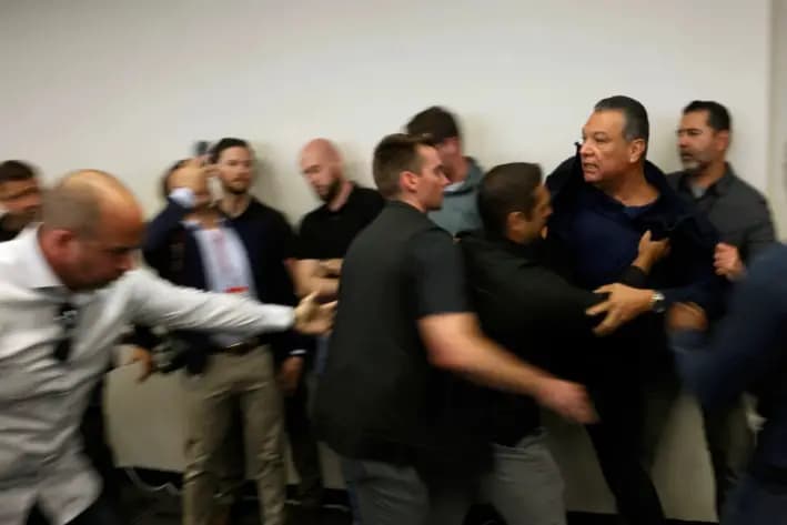 El senador Alex Padilla (D-Calif.) es empujado fuera de la sala mientras la secretaria de Seguridad Nacional, Kristi Noem, ofrece una conferencia de prensa sobre las recientes protestas en Los Ángeles, el 12 de junio de 2025. (Etienne Laurent/AP Photo)
