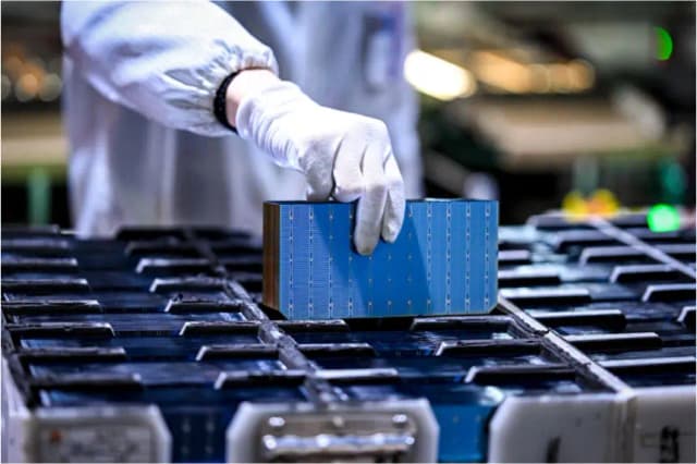 Un trabajador sostiene una parte de los módulos fotovoltaicos para paneles solares en una fábrica en Suqian, provincia de Jiangsu, China, el 23 de enero de 2025. (STR/AFP vía Getty Images)