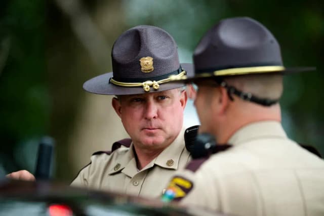 Agentes de la Patrulla Estatal de Minnesota bloquean una carretera mientras las fuerzas policiales registran los alrededores de un vehículo en Belle Plaine, Minnesota, tras el tiroteo contra varios legisladores estatales, el 15 de junio de 2025. (Stephen Maturen/Getty Images)
