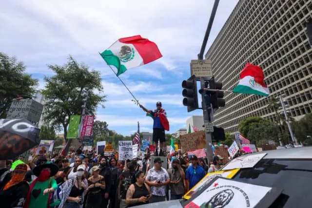 Un hombre ondea una bandera mexicana mientras la gente participa en la manifestación «Sin Reyes» para protestar contra ICE, Trump y sus políticas, en Los Ángeles, el 14 de junio de 2025. (Sahab Zaribaf/Middle East Images vía AFP vía Getty Images)