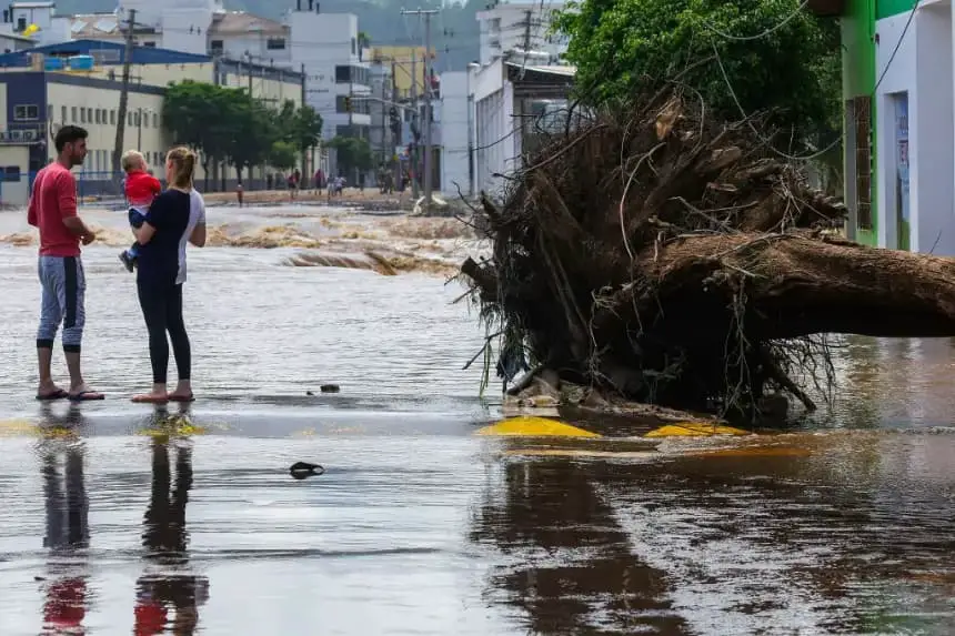 Los lugareños permanecen junto a un árbol caído luego de las inundaciones causadas por las fuertes lluvias, en Roca Sales, estado de Rio Grande do Sul, Brasil, el 19 de noviembre de 2023. (Silvio Avila/AFP vía Getty Images)