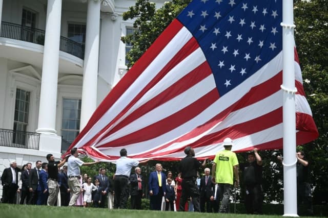 El presidente Donald Trump observa mientras se iza una bandera estadounidense en un mástil recién instalado en el jardín sur de la Casa Blanca en Washington, el 18 de junio de 2025. (Brendan Smialowki/AFP a través de Getty Images)