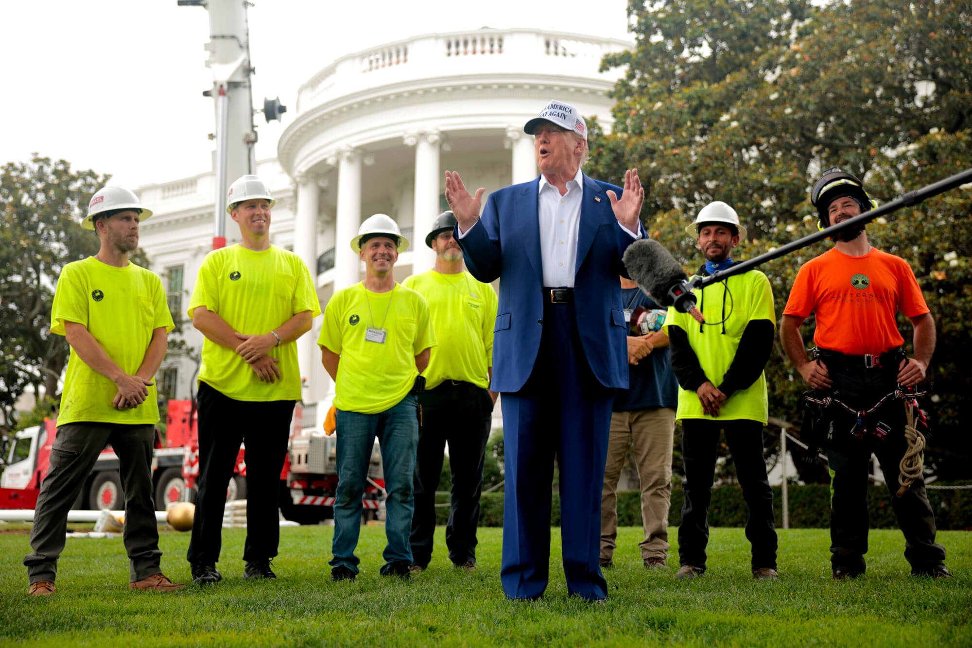 Junto a los trabajadores antes de instalar un nuevo mástil en el Jardín Sur, el presidente estadounidense Donald Trump conversa con periodistas frente a la Casa Blanca el 18 de junio de 2025 en Washington, D.C. Trump afirmó haber pagado personalmente el mástil y otro similar en el Jardín Norte, así como sus instalaciones. (Chip Somodevilla/Getty Images)