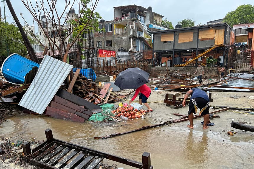 Los lugareños caminan entre los escombros tras el paso del huracán Erick en Bahía Principal, Puerto Escondido, estado de Oaxaca, México, el 19 de junio de 2025. (Carlo Echegoyen/AFP vía Getty Images