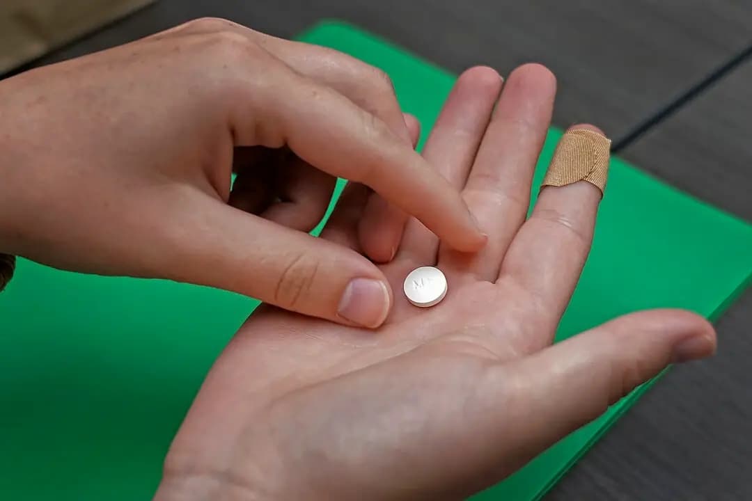 Una paciente se prepara para tomar la primera de dos píldoras combinadas, mifepristona, para un aborto con medicamentos durante una visita a una clínica en Kansas City, Kansas, el 12 de octubre de 2022. (AP Photo/Charlie Riedel)