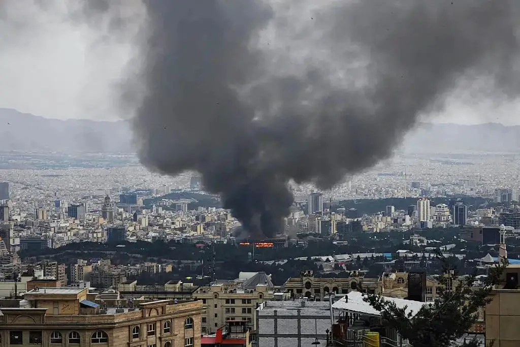 Humo tras un ataque israelí contra un edificio utilizado por la cadena de televisión estatal iraní, el 16 de junio de 2025 en Teherán, Irán. (Stringer/Getty Images)
