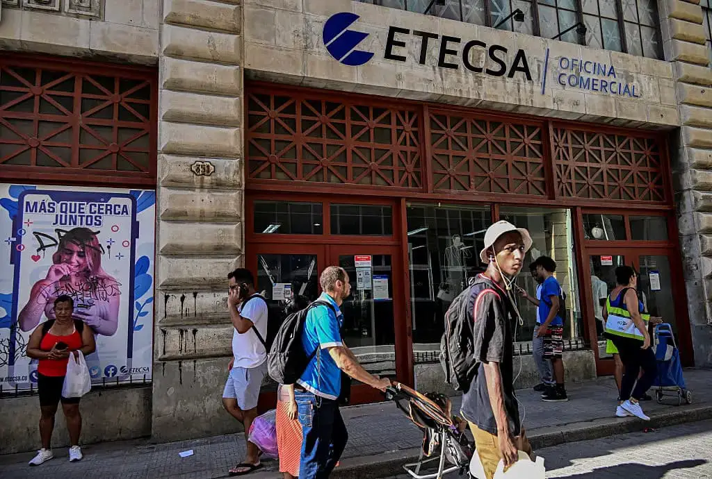 Personas pasan frente a la oficina comercial de la Empresa de Telecomunicaciones de Cuba (Etecsa) en La Habana el 10 de junio de 2025. Las nuevas tarifas de internet móvil en Cuba provocaron una conmoción entre los estudiantes universitarios, algo inédito desde antes del triunfo de la revolución, en una movilización que refleja la exasperación social ante la creciente dolarización de la economía, la caída del nivel de vida y la desigualdad. (AMIL LAGE/AFP vía Getty Images)