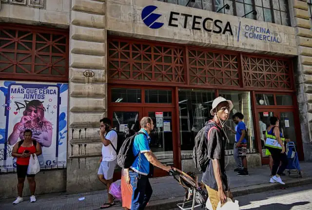 Personas pasan frente a la oficina comercial de la Empresa de Telecomunicaciones de Cuba (Etecsa) en La Habana el 10 de junio de 2025. Las nuevas tarifas de internet móvil en Cuba provocaron una conmoción entre los estudiantes universitarios, algo inédito desde antes del triunfo de la revolución, en una movilización que refleja la exasperación social ante la creciente dolarización de la economía, la caída del nivel de vida y la desigualdad. (AMIL LAGE/AFP vía Getty Images)