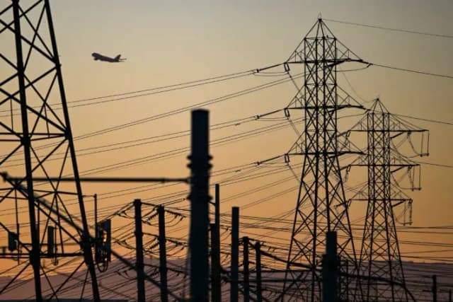 Un avión despega del Aeropuerto Internacional de Los Ángeles tras cables de alta tensión en El Segundo, California, el 31 de agosto de 2022. (Patrick T. Fallon/AFP vía Getty Images)