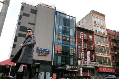 Personas pasan junto a un edificio (en el centro) que se sospecha que es utilizado como comisaría secreta en Chinatown con el fin de reprimir a los disidentes que viven en Estados Unidos en nombre del Gobierno chino, en el bajo Manhattan de Nueva York, el 18 de abril de 2023. (Spencer Platt/Getty Images).