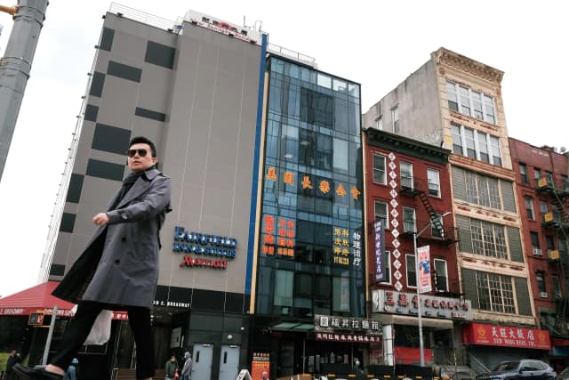 Personas pasan junto a un edificio (en el centro) que se sospecha que es utilizado como comisaría secreta en Chinatown con el fin de reprimir a los disidentes que viven en Estados Unidos en nombre del Gobierno chino, en el bajo Manhattan de Nueva York, el 18 de abril de 2023. (Spencer Platt/Getty Images).