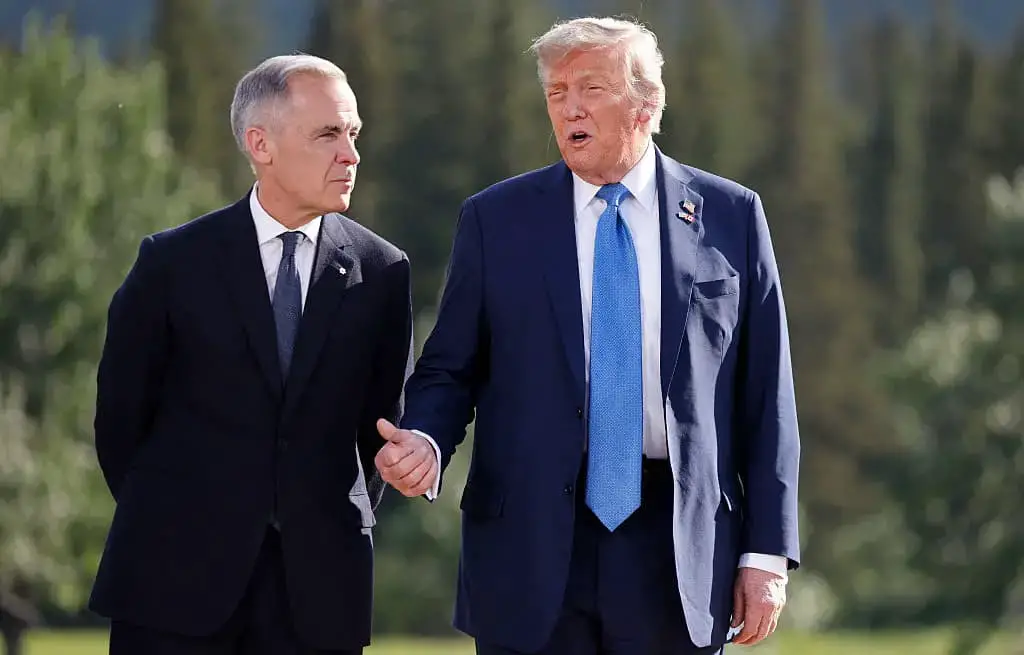 (De izquierda a derecha) El primer ministro canadiense, Mark Carney, y el presidente estadounidense, Donald Trump, conversan durante una foto familiar en la cumbre del Grupo de los Siete (G7) en el campo de golf Kananaskis Country, en Kananaskis, Alberta (Canadá), el 16 de junio de 2025. (LUDOVIC MARIN/POOL/AFP a través de Getty Images)
