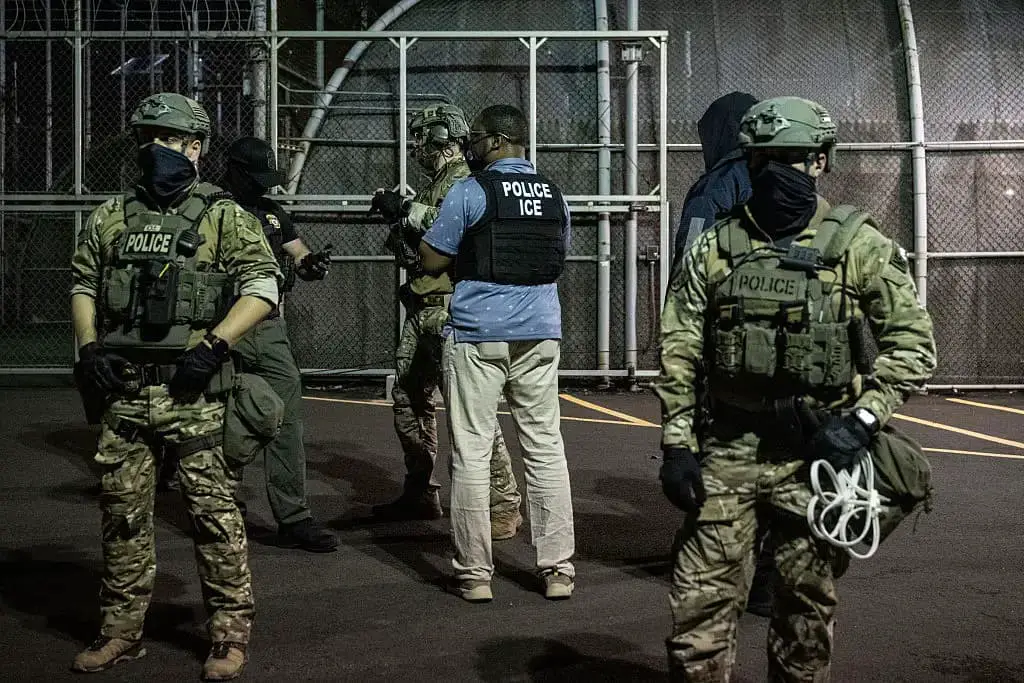 Agentes del Servicio de Inmigración y Control de Aduanas de Estados Unidos (ICE) vigilan el exterior de Delaney Hall, un centro de detención de inmigrantes, mientras activistas contra el ICE se manifiestan, el 12 de junio de 2025, en Newark, Nueva Jersey. (Stephanie Keith/Getty Images)