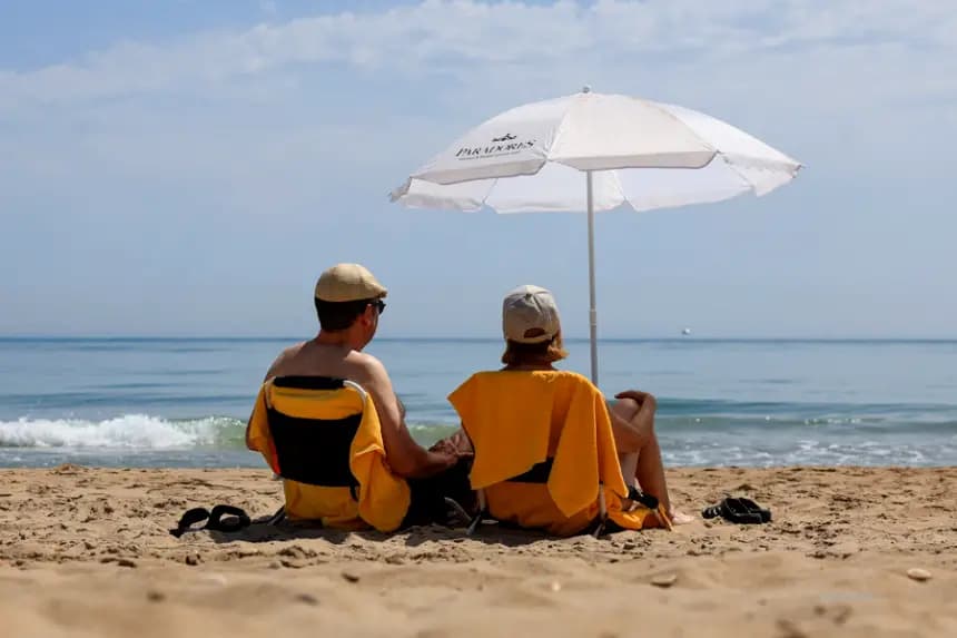Dos personas disfrutan de un día de playa en El Saller, Valencia, el 25 de junio de 2025. EFE/Kai Forsterling