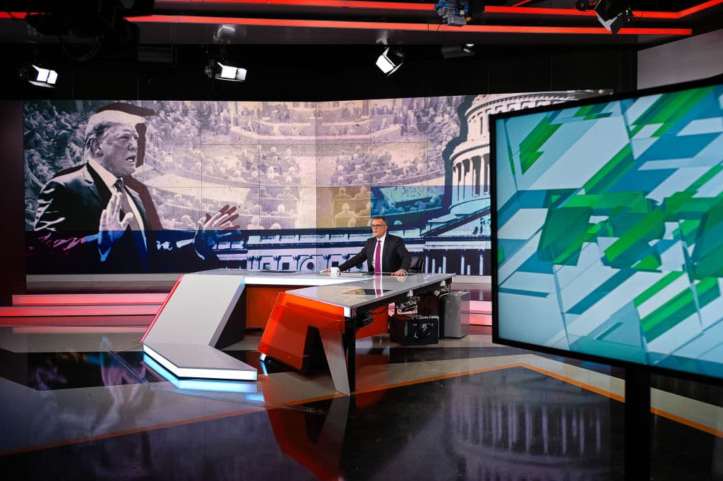 El presentador de noticias Kevin Owen informa sobre el juicio político al presidente estadounidense Donald Trump durante una transmisión de RT el 6 de diciembre de 2019 en Moscú, Rusia. RT, antes conocida como Russia Today, es una cadena de televisión estatal que produce contenido informativo en inglés y otros idiomas. La cadena insiste en no diferenciarse de otras emisoras globales, como la BBC, si bien ofrece perspectivas alternativas a los principales medios occidentales. Sin embargo, los gobiernos occidentales la ven como un instrumento del gobierno ruso. (Misha Friedman/Getty Images)