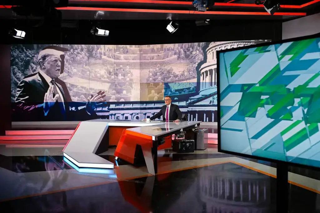 El presentador de noticias Kevin Owen informa sobre el juicio político al presidente estadounidense Donald Trump durante una transmisión de RT el 6 de diciembre de 2019 en Moscú, Rusia. RT, antes conocida como Russia Today, es una cadena de televisión estatal que produce contenido informativo en inglés y otros idiomas. La cadena insiste en no diferenciarse de otras emisoras globales, como la BBC, si bien ofrece perspectivas alternativas a los principales medios occidentales. Sin embargo, los gobiernos occidentales la ven como un instrumento del gobierno ruso. (Misha Friedman/Getty Images)
