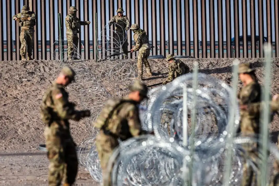 Soldados de la Guardia Nacional de Texas desenrollan alambre de púas cerca de la valla fronteriza entre Estados Unidos y México en El Paso, Texas. (John Moore/Getty Images)
