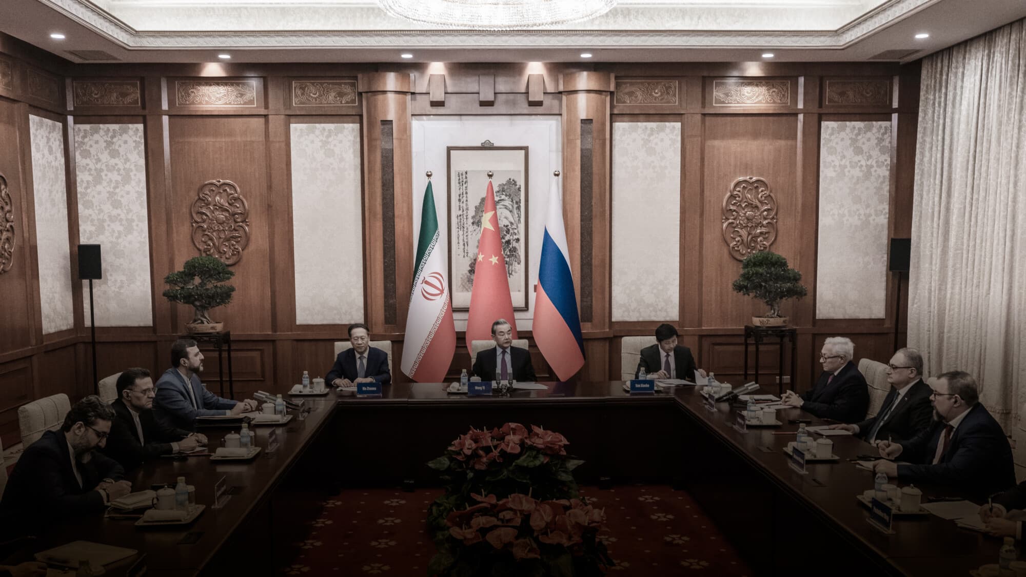 El ministro de Asuntos Exteriores chino, Wag Yi (centro), preside una reunión con el viceministro de Asuntos Exteriores ruso, Sergey Ryabkov (arriba a la derecha), y el viceministro de Asuntos Exteriores iraní, Kazeem Gharibabadi (arriba a la izquierda), durante una reunión sobre la cuestión nuclear iraní en la Residencia Oficial de Diaoyutai, en Pekín, el 14 de marzo de 2025. El Partido Comunista Chino (PCCh) condenó los recientes ataques israelíes y estadounidenses contra instalaciones nucleares y militares iraníes como una violación de la soberanía iraní. (Stringer/Getty Images).