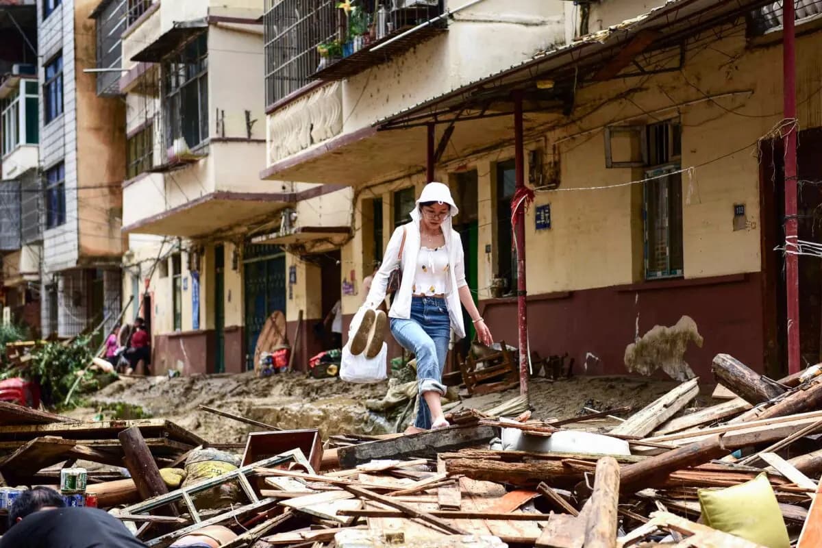 Una mujer camina entre los escombros en una zona afectada por las inundaciones en Congjiang, en el suroeste de la provincia de Guizhou, China, el 25 de junio de 2025. (STR/AFP vía Getty Images)