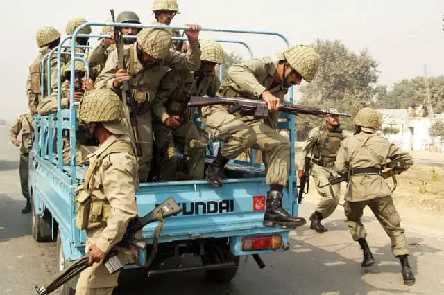 Soldados paramilitares paquistaníes saltaron de un camión mientras tomaban posición afuera de un centro de entrenamiento policial luego de que hombres armados atacaron en Lahore el 15 de octubre de 2009. (Arif Ali/AFP vía Getty Images)