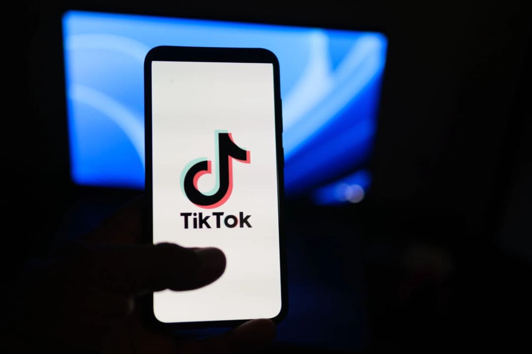 Un hombre sostiene un teléfono que muestra la aplicación TikTok, el 11 de agosto de 2024. (Oleksii Pydsosonnii/The Epoch Times)