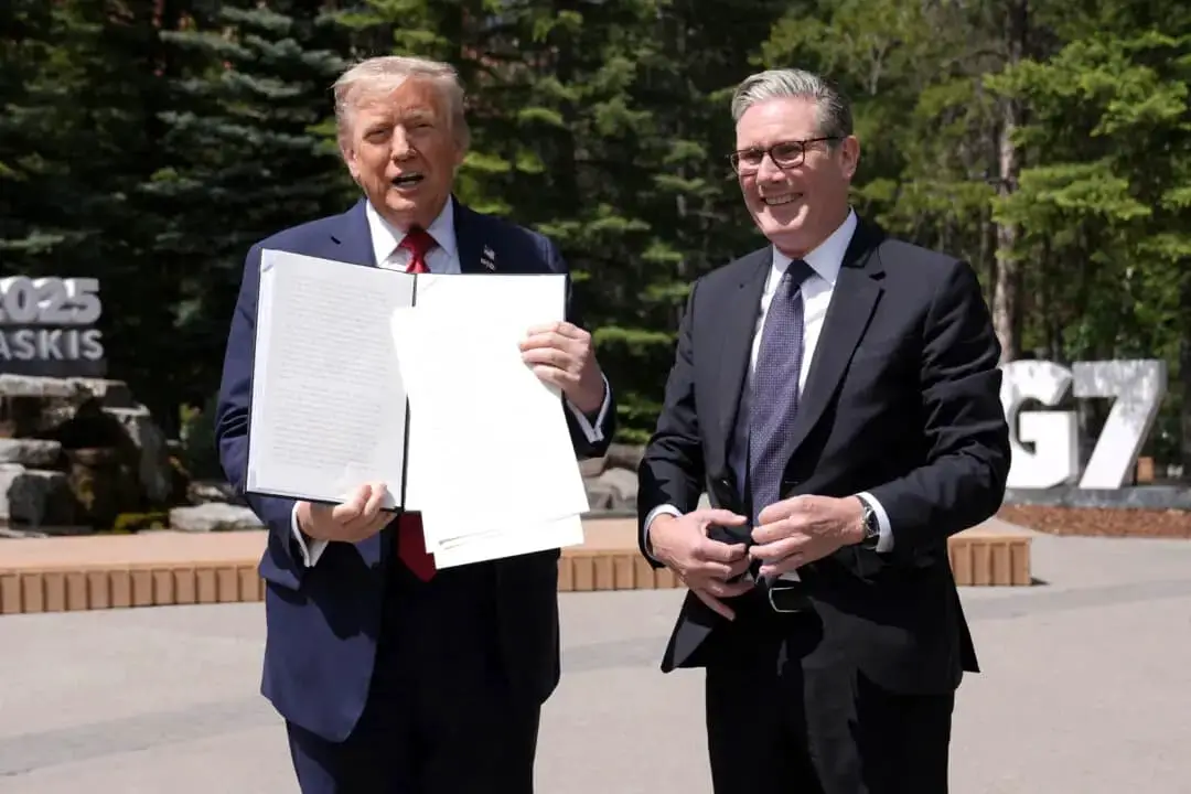El presidente de Estados Unidos, Donald Trump (izquierda), sostiene un acuerdo comercial firmado entre Estados Unidos y el Reino Unido junto al primer ministro británico, Keir Starmer, mientras hablan con los periodistas durante la cumbre del Grupo de los Siete (G7) en el Pomeroy Kananaskis Mountain Lodge en Kananaskis, Alberta (Canadá), el 16 de junio de 2025. (Stefan Rousseau/Pool/AFP a través de Getty Images)
