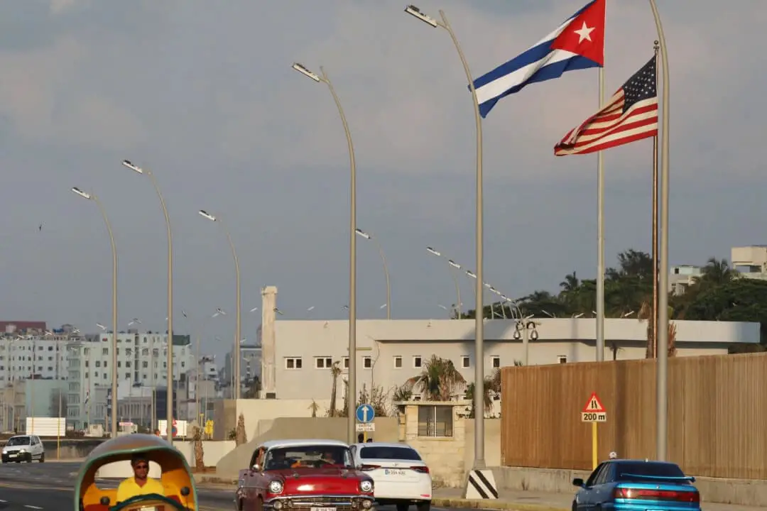 Carros pasan junto a banderas cubanas y estadounidenses frente a la embajada de Estados Unidos en La Habana, Cuba, el 13 de mayo de 2024. (Alexandre Meneghini/Reuters)