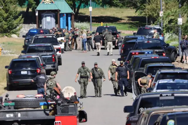 Las fuerzas del orden y los servicios de emergencia en Cherry Hill Park, junto a la calle 15, tras recibir informes de un ataque con emboscada en Canfield Mountain, en Coeur d'Alene, Idaho, el 29 de junio de 2025. (Bill Buley/Coeur D'Alene Press a través de AP).