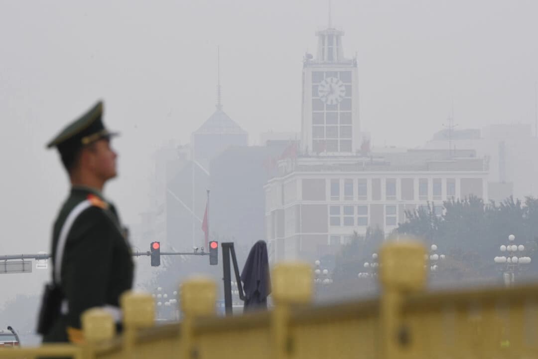 Un policía paramilitar chino monta guardia en la plaza de Tiananmen antes de la presentación del Comité Permanente del Politburó del Partido Comunista Chino, el máximo órgano de decisión del país, en un día contaminado en Pekín, el 25 de octubre de 2017. (Greg Baker/AFP a través de Getty Images)