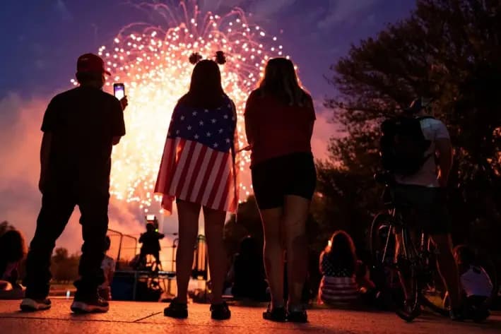 Los visitantes observan el espectáculo de fuegos artificiales del Día de la Independencia cerca del Monumento a Lincoln en el National Mall, en Washington, el 4 de julio de 2021. (Alex Edelman/AFP vía Getty Images)