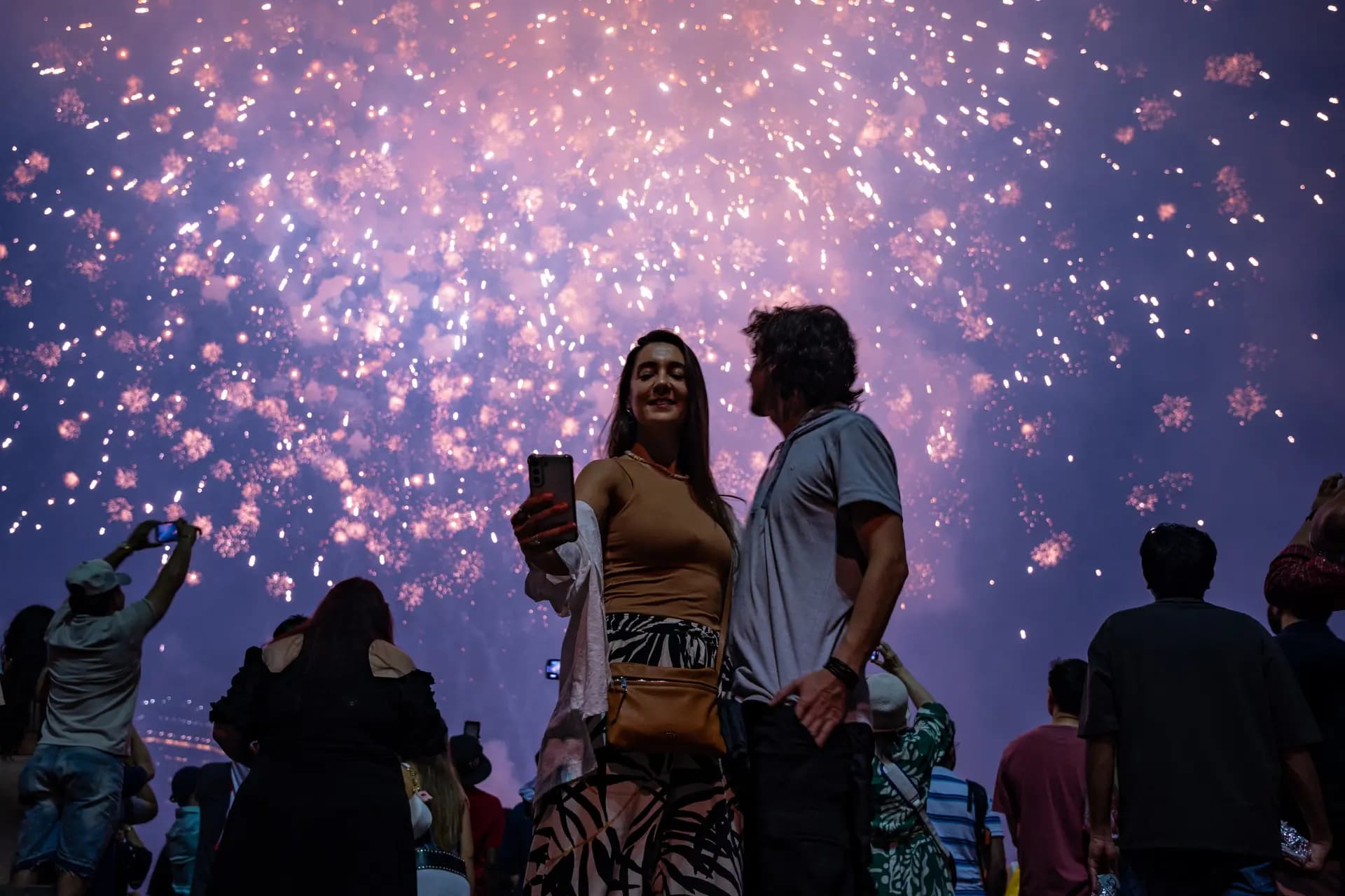 Una mujer se toma una selfie mientras los fuegos artificiales iluminan el cielo durante la celebración del 4 de julio de Macy's en el East River en Brooklyn Bridge Park en la ciudad de Nueva York el 4 de julio de 2025. (Angelina Katsanis/AFP vía Getty Images)