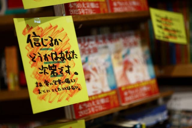 Un cartel de venta con la leyenda "Créelo o no, depende de ti", se exhibe junto al cómic "El futuro que vi", del mangaka Ryo Tatsuki, en la librería Village Vanguard de Tokio, Japón, el 30 de junio de 2025. (Issei Kato/Reuters)
