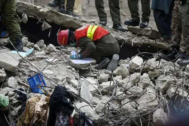 Un rescatista rescata a víctimas entre los escombros tras el derrumbe de un edificio residencial en Karachi (Pakistán) el 4 de julio de 2025. (Rizwan Tabassum/AFP vía Getty Images)