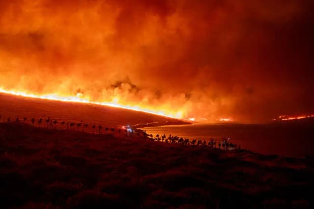 Humo y bengalas se elevan desde una zona boscosa tras un incendio forestal en el distrito de Cesme, en Izmir, Turquía, el 3 de julio de 2025. (Murat Kocabas/Middle East Images/AFP vía Getty Images)
