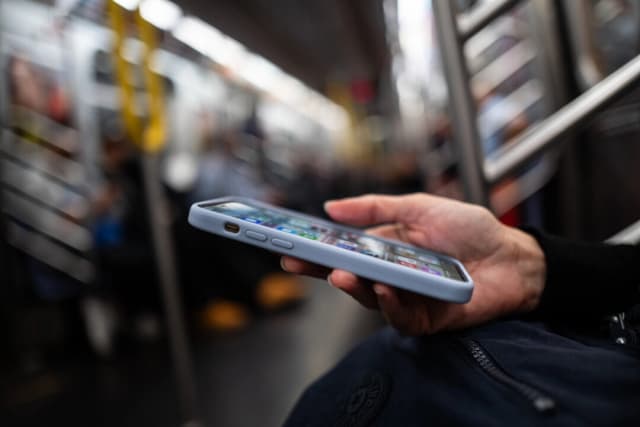 Una persona sostiene un teléfono en la ciudad de Nueva York el 17 de junio de 2025. (Madalina Kilroy/The Epoch Times)