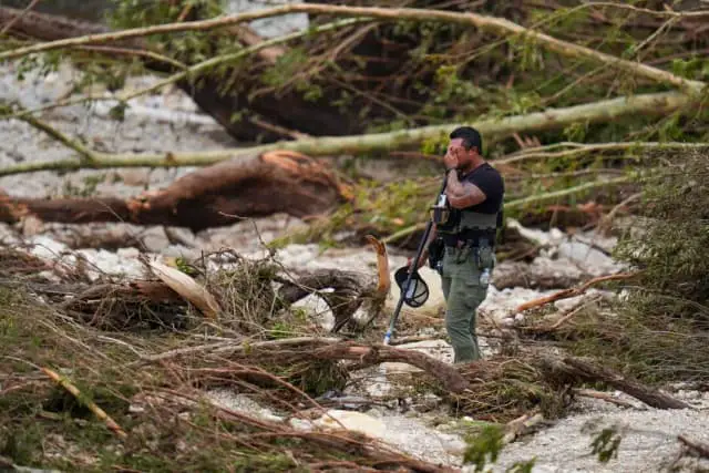Un ayudante del sheriff hace una pausa mientras peina las orillas del río Guadalupe, cerca de Camp Mystic, después de que una riada arrasara la zona en Hunt, Texas, el 5 de julio de 2025. (Julio Cortez/AP Photo)