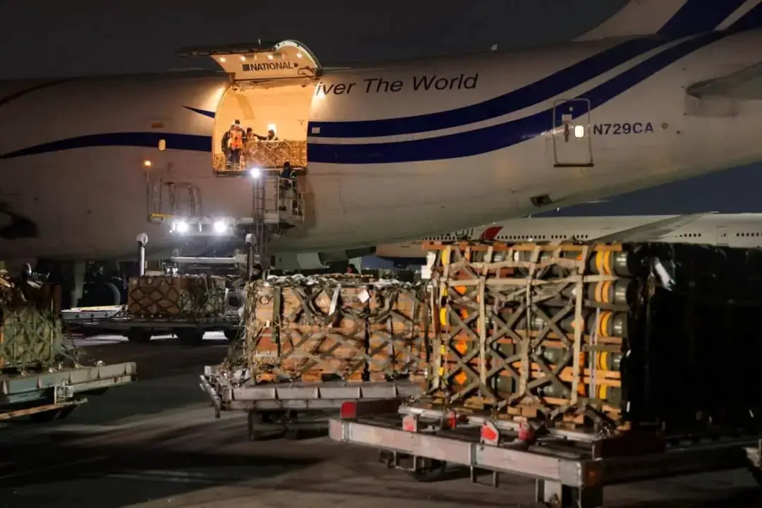 Personal de tierra descarga armas, incluidos misiles antitanque Javelin, y otro material militar entregado en un avión de National Airlines por el ejército de Estados Unidos en el aeropuerto de Boryspil, cerca de Kyiv, en Boryspil, Ucrania, el 25 de enero de 2022. (Sean Gallup/Getty Images)