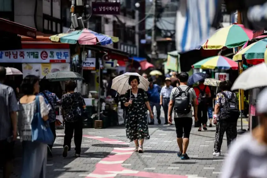 Una mujer usa una sombrilla para protegerse del sol en un mercado de Seúl (Corea del Sur) el 16 de agosto de 2024, durante una prolongada ola de calor que ha afectado a gran parte del país. (Anthony Wallace/AFP vía Getty Images)