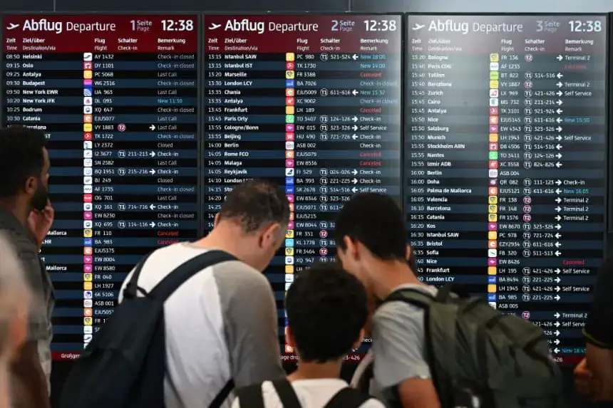 Los pasajeros se encuentran frente a una pantalla que anuncia vuelos en el Aeropuerto BER de Berlín-Brandeburgo en Schoenefeld, al suroeste de la capital alemana, el 19 de julio de 2024. (Ralf Hirschberger/AFP vía Getty Images)
