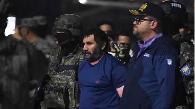 El narcotraficante Adolfo Macias, alias Fito, es custodiado por el ministro del Interior de Ecuador, John Reimberg (derecha), y personal militar a su llegada a la base aérea de Guayaquil, Ecuador, el 25 de junio de 2025, tras su recaptura en Manta, provincia de Manabí. (Marcos Pin/AFP vía Getty Images)