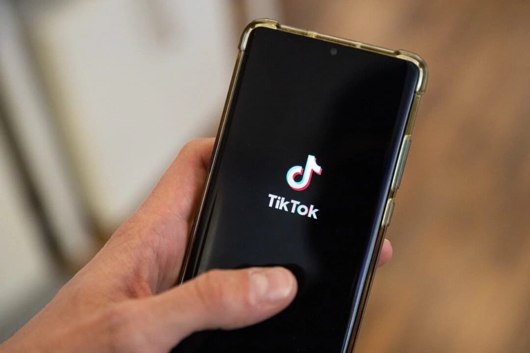 Un hombre sostiene un teléfono inteligente con el logotipo de la plataforma china de redes sociales TikTok en una oficina de París el 19 de abril de 2024. (Antonin Utz/AFP a través de Getty Images)