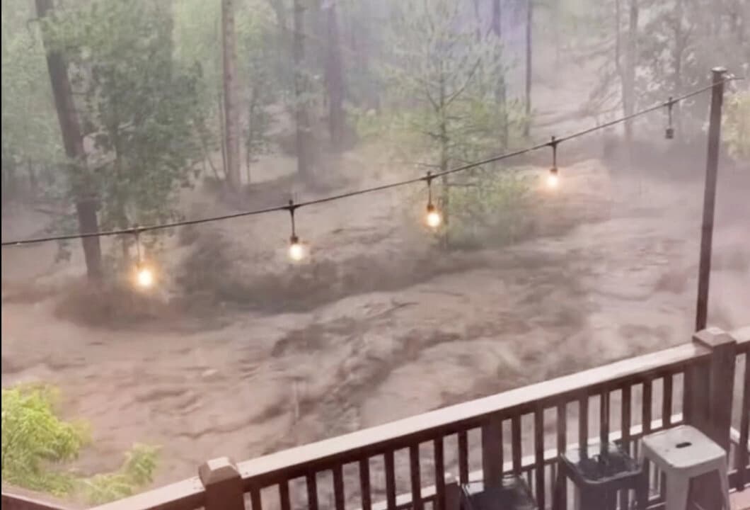 Se observa una inundación repentina detrás de una casa en Ruidoso, Nuevo México, el 8 de julio de 2025, en una imagen de video. (Kaitlyn Carpenter vía AP)
