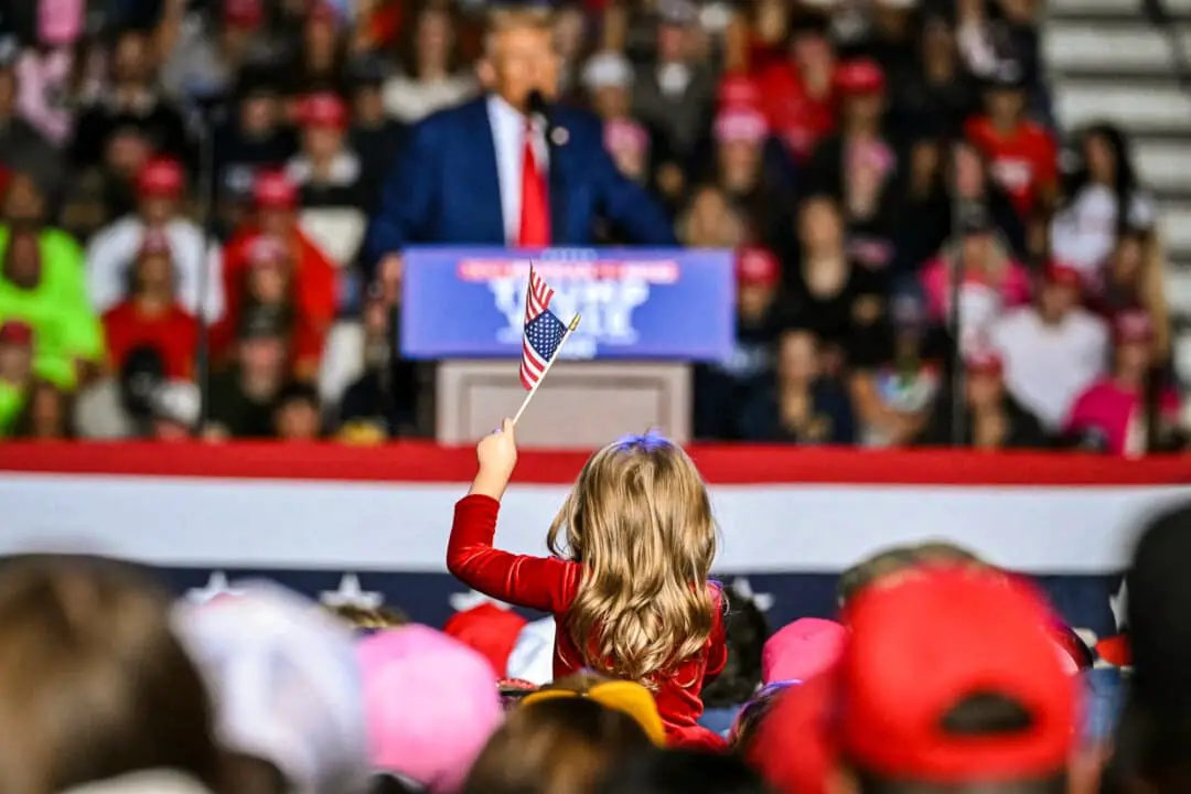 Una niña sostiene una bandera estadounidense mientras el candidato presidencial republicano y expresidente Donald Trump habla durante un mitin de campaña en la Universidad Estatal de Saginaw Valley, en Saginaw (Míchigan), el 3 de octubre de 2024. (Jim Watson/AFP a través de Getty Images)