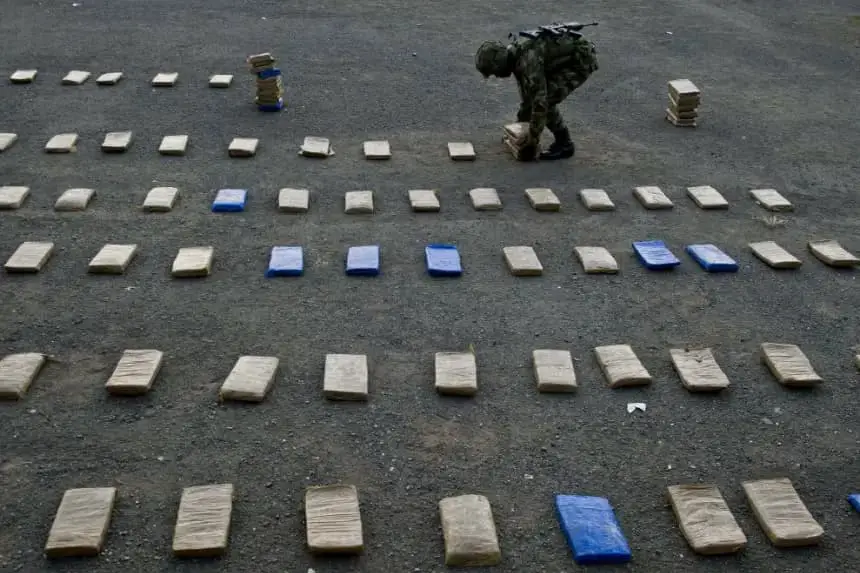 Un soldado colombiano recoge paquetes de marihuana durante una conferencia de prensa en Cali, Colombia, el 11 de abril de 2014. (Luis Robayo/AFP vía Getty Images)