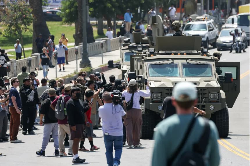 Multitudes observan a agentes federales de la Patrulla Fronteriza y de Aduanas de Estados Unidos (CBP) a bordo de un vehículo blindado que avanza lentamente por Whilshire Boulevard, cerca del Parque MacArthur en Los Ángeles, el 7 de julio de 2025. (Patrick T. Fallon/AFP vía Getty Images)