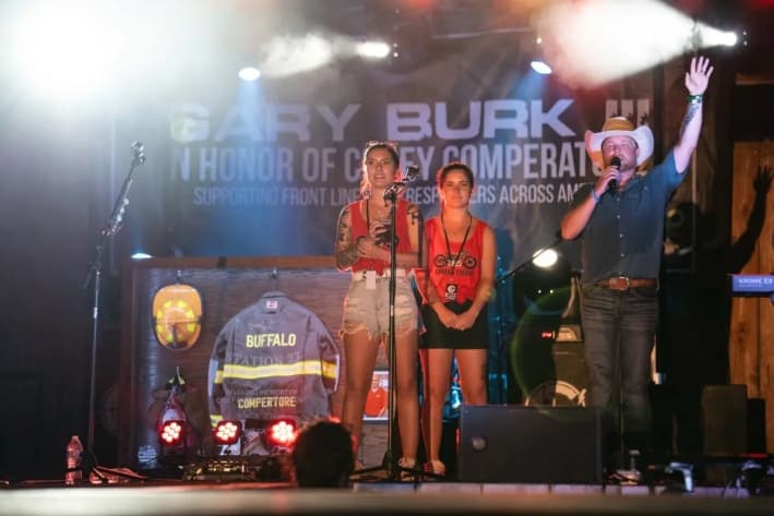 Kaylee (derecha) y Allyson Comperatore hablaron durante una canción de Gary Buck III en honor a Corey Comperatore en Russellton, Pensilvania, el 12 de julio de 2025. (Samira Bouaou/The Epoch Times)