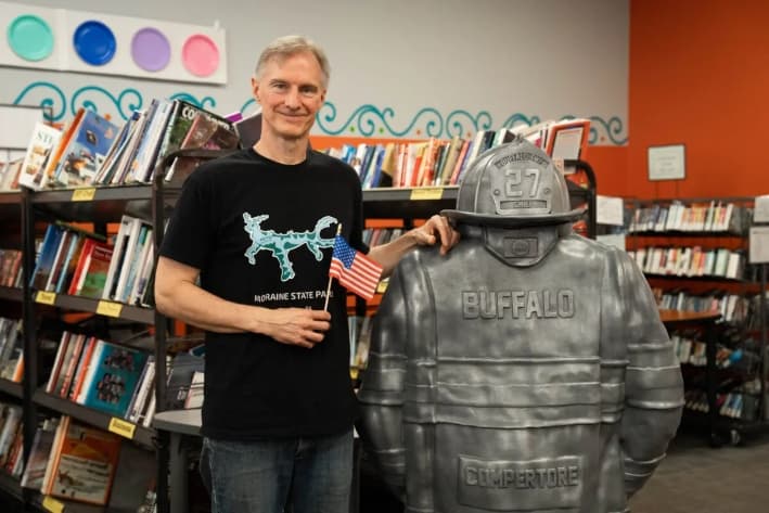 Christopher Tomko junto a su escultura del traje de bombero de Corey Comperatore en la Biblioteca Comunitaria South Butler de Saxonburg, Pensilvania, el 12 de julio de 2025. (Samira Bouaou/The Epoch Times)