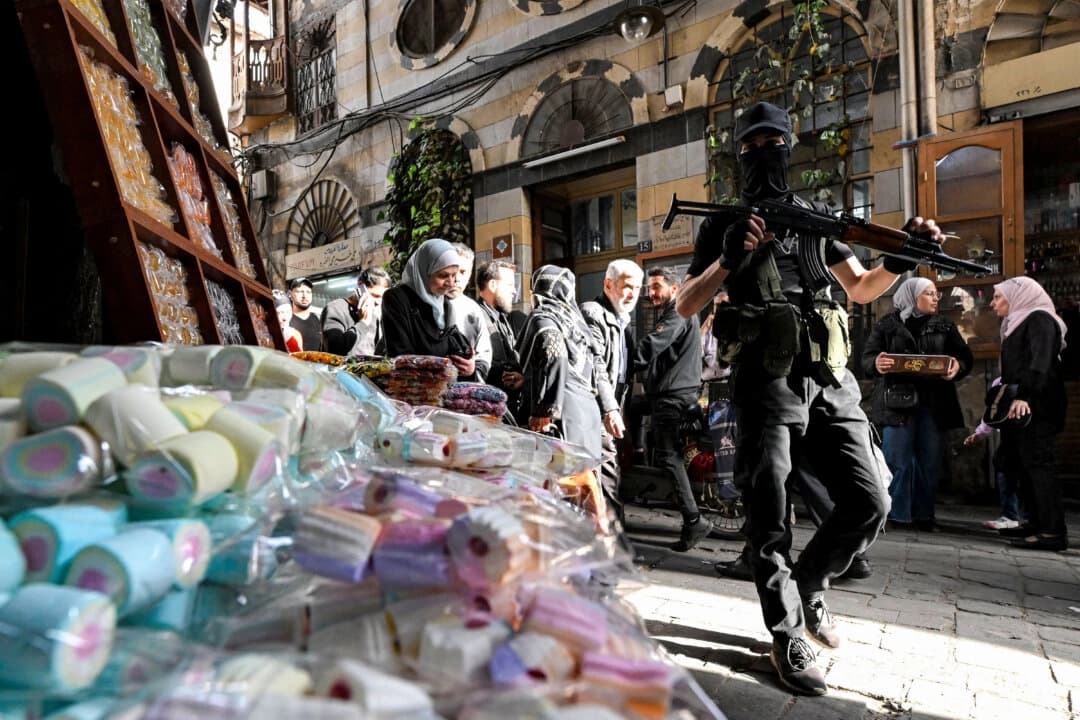 Un combatiente enmascarado camina con una ametralladora en el mercado cubierto de Damasco el 29 de marzo de 2025. (LOUAI BESHARA/AFP a través de Getty Images).